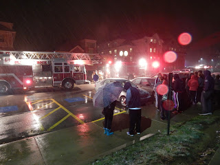 Students wait outside in the snow as firefighters investigate a burning smell in Watson Hall.
